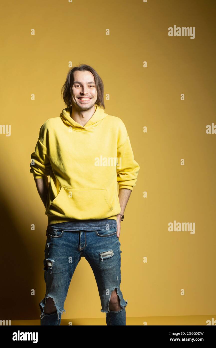 Ritratto Felice giovane in felpa e jeans strappati Foto Stock