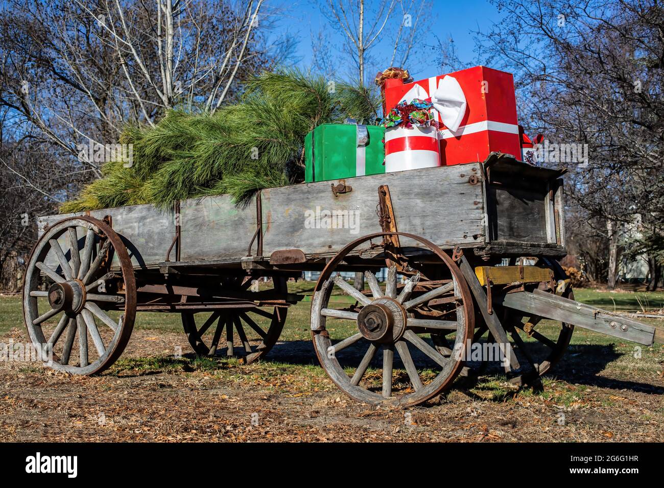 Carro vecchio stile pieno di regali e un albero di Natale; decorazione per le vacanze di Natale. Foto Stock