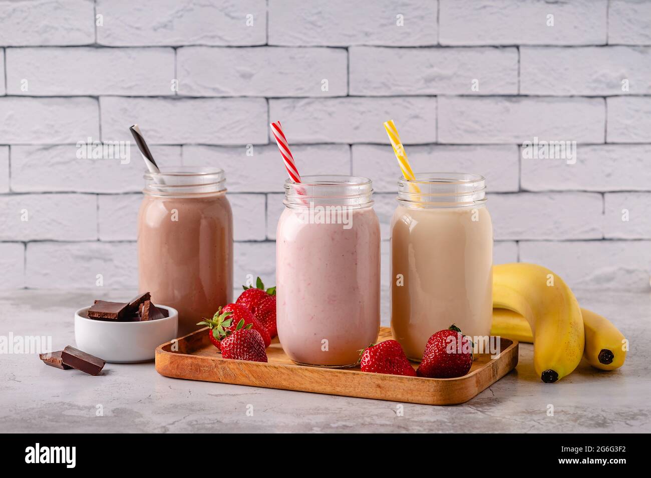Set di fragole banana e cioccolato milkshake nei vasi di vetro Foto Stock