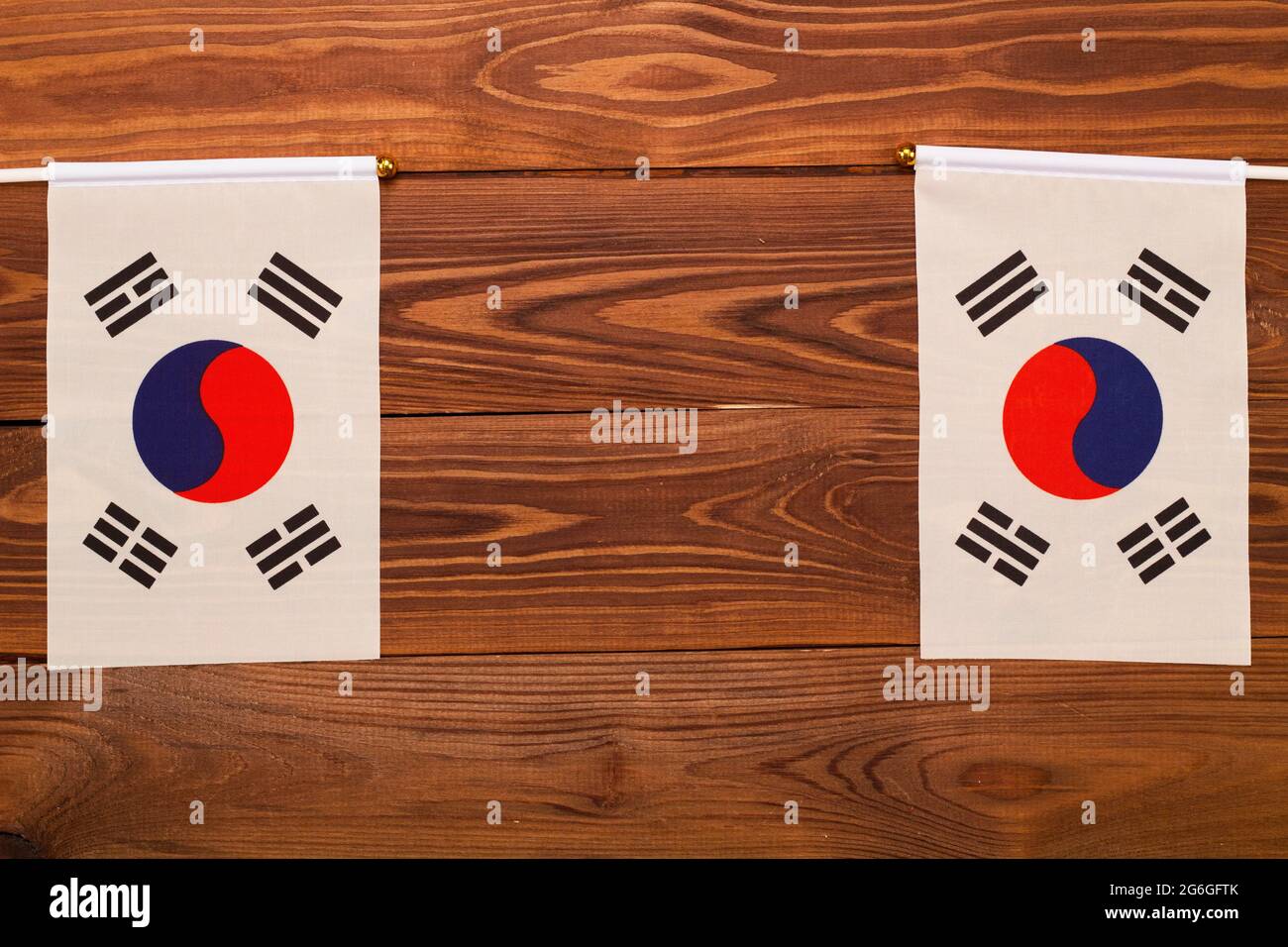 Bandiere della Corea del Sud su entrambi i lati con spazio di copia per il testo su sfondo di legno marrone. Bandiere di festa nella Giornata Nazionale di Liberazione della Corea. Foto Stock