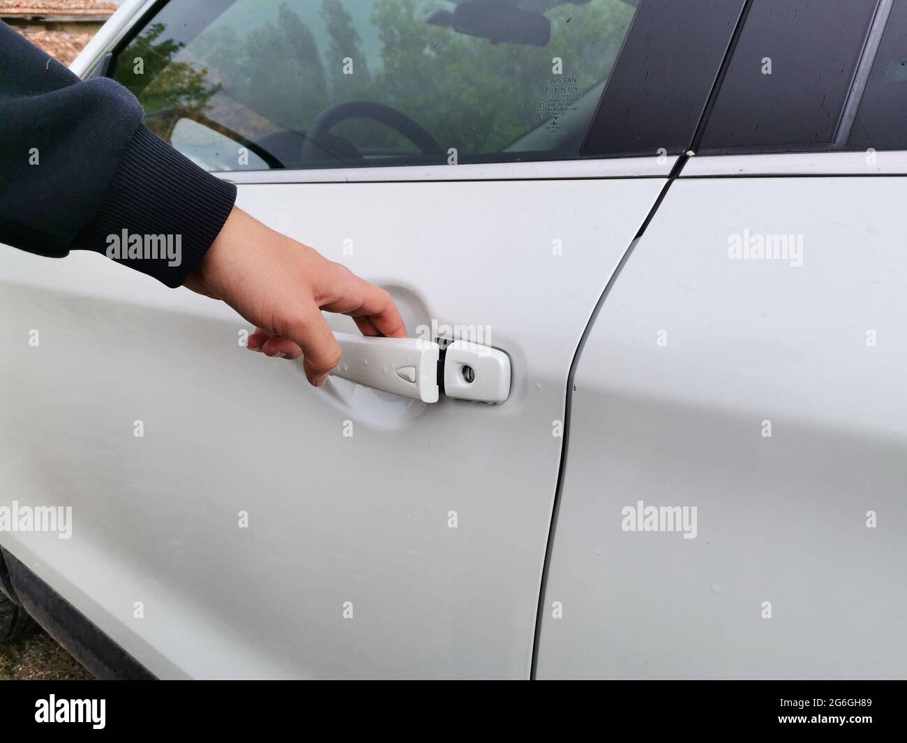 Apertura manuale della porta dell'auto. Auto bianca. Utilizzando un'auto. Foto Stock