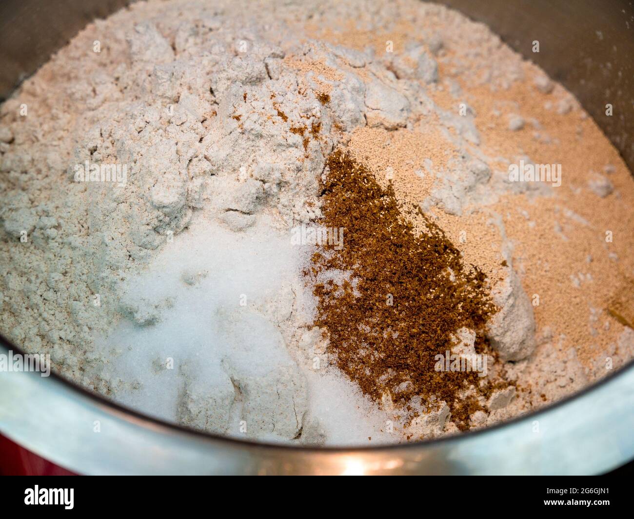 Farina di segale, sale, cumino macinato e lievito secco in un recipiente in acciaio inox - base per l'impasto del pane - fuoco selettivo Foto Stock