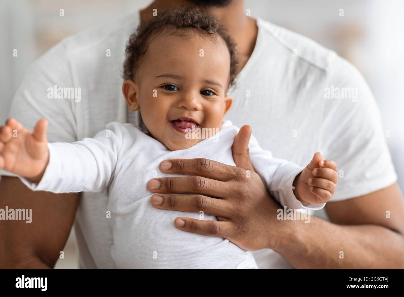 Primo piano Ritratto dell'adorabile bambino nero che si rilassa nelle mani del Padre Foto Stock