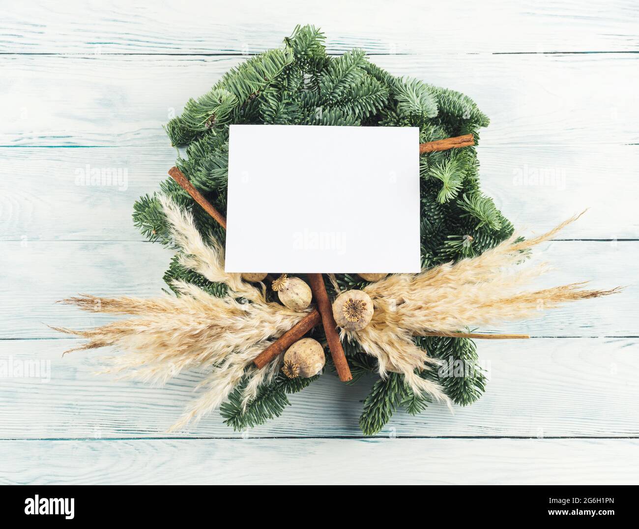 Naturale natale abete rosso ardesia decorazione wreath con vuoto biglietto d'auguri su sfondo di legno Foto Stock