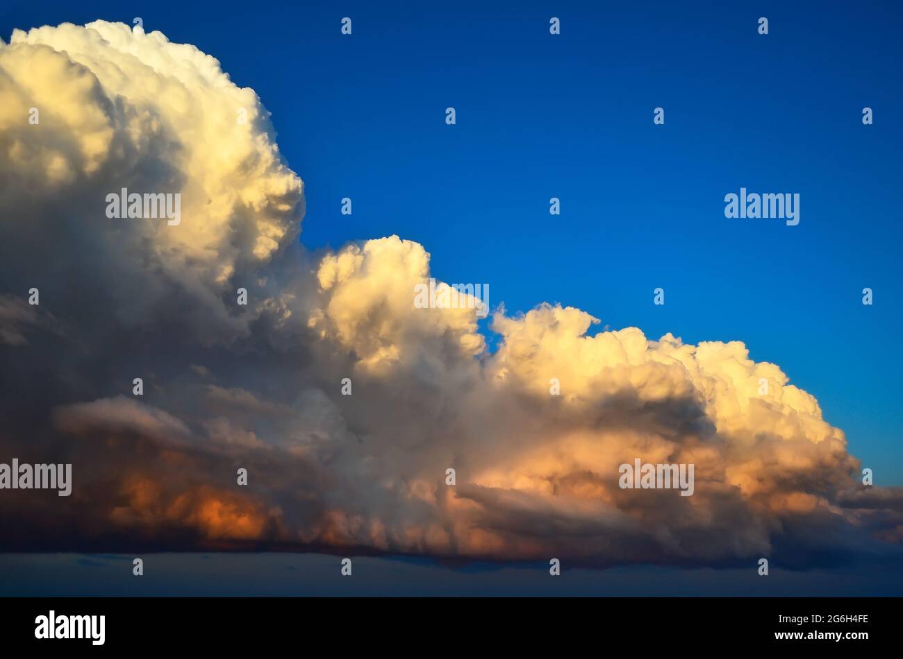 Grandiose e potenti nuvole di cumulo al tramonto in cielo blu Foto Stock
