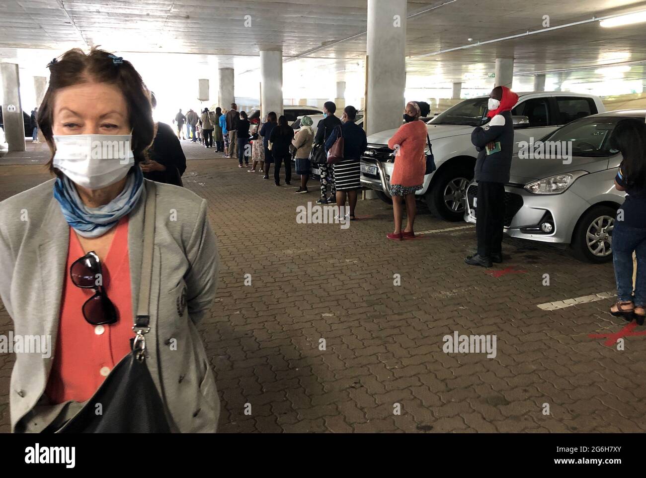 Durban, Sudafrica. 06 luglio 2021. Persone in attesa di essere vaccinate contro Covid-19 in un parcheggio ponte convertito in un centro di vaccinazione presso l'ospedale St. Augustine's Hospital nella città portuale sudafricana di Durban. Secondo un membro del personale, circa 2,500 - 3,000 persone sono attualmente vaccinate qui al giorno. Credit: Ralf Krüger/dpa/Alamy Live News Foto Stock