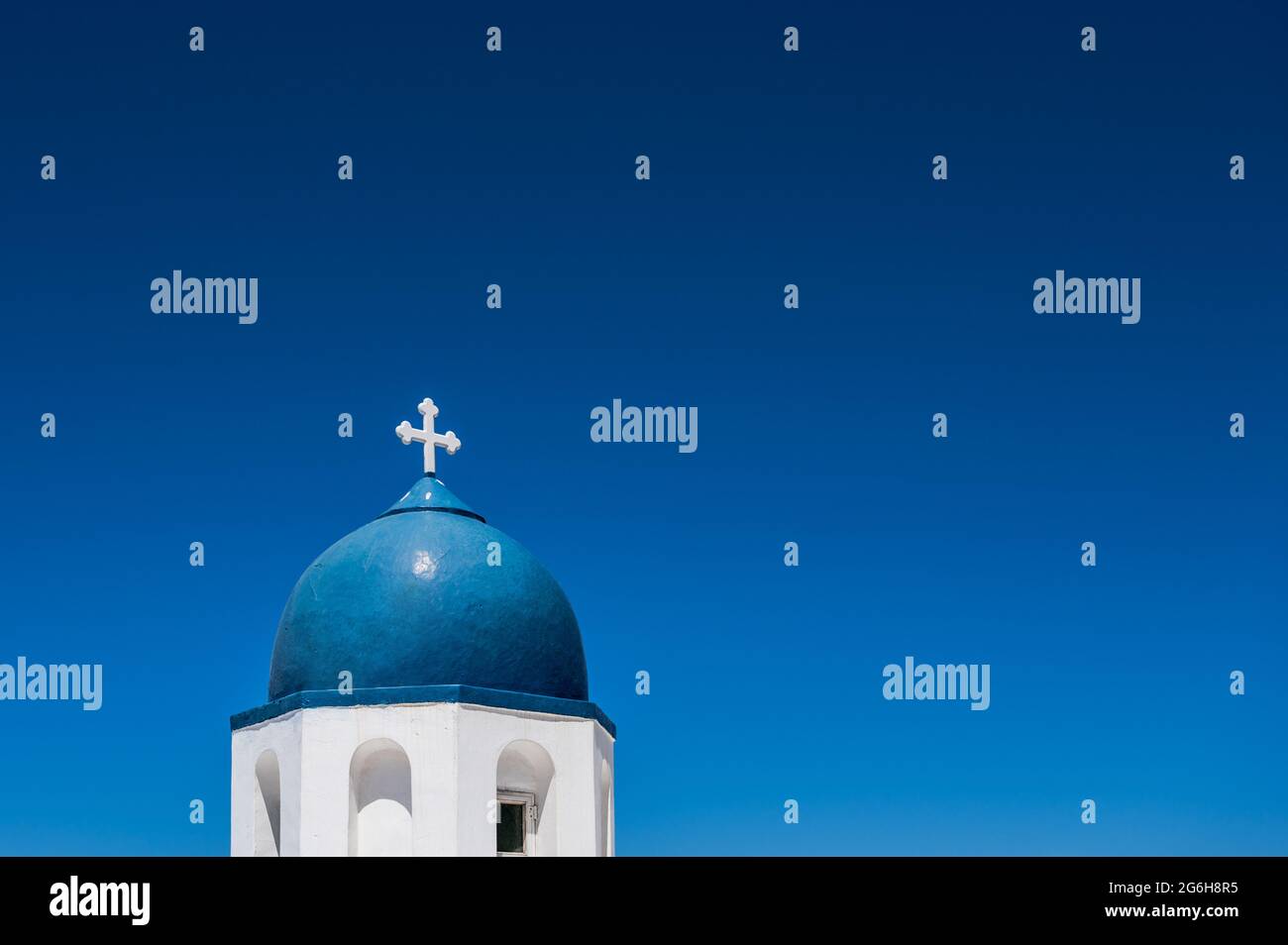 Il campanile bianco e blu della tradizionale chiesa greco-ortodossa sull'isola di Santorini. Cielo blu su sfondo. Foto Stock