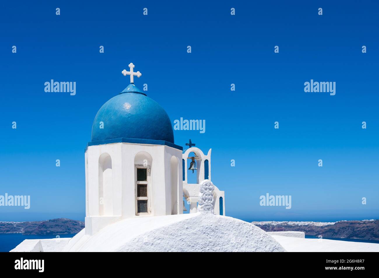 Il campanile bianco e blu della tradizionale chiesa greco-ortodossa sull'isola di Santorini. Cielo blu su sfondo. Foto Stock