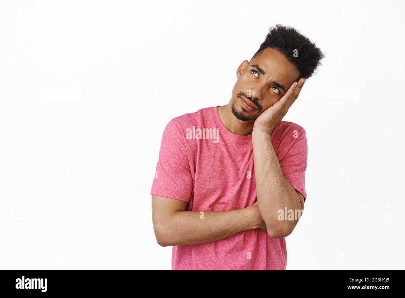 Annoiato e infastidito aloamericano maschio studente, ragazzo rotolare gli occhi e fissando con vuoto distanziato verso l'esterno faccia in alto a sinistra, assistere noioso annoiarsi Foto Stock