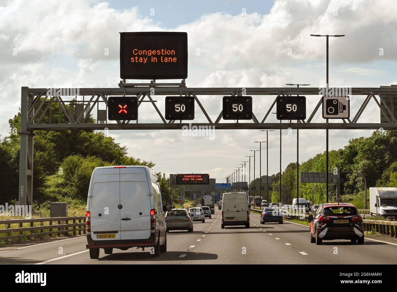 Bristol, Inghilterra - Giugno 2021: Portale sospeso sull'autostrada M4 con indicazioni stradali che indicano il limite di velocità e una corsia chiusa. Foto Stock