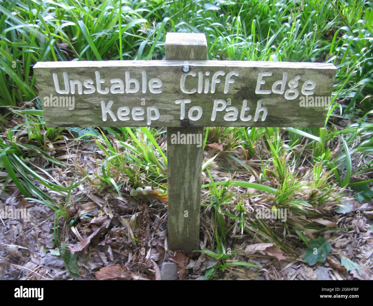 Instabile scogliera bordo tenere a percorso legno segno. Sentiero della costa sud-occidentale. Devon nord. Paese occidentale. Inghilterra. REGNO UNITO Foto Stock