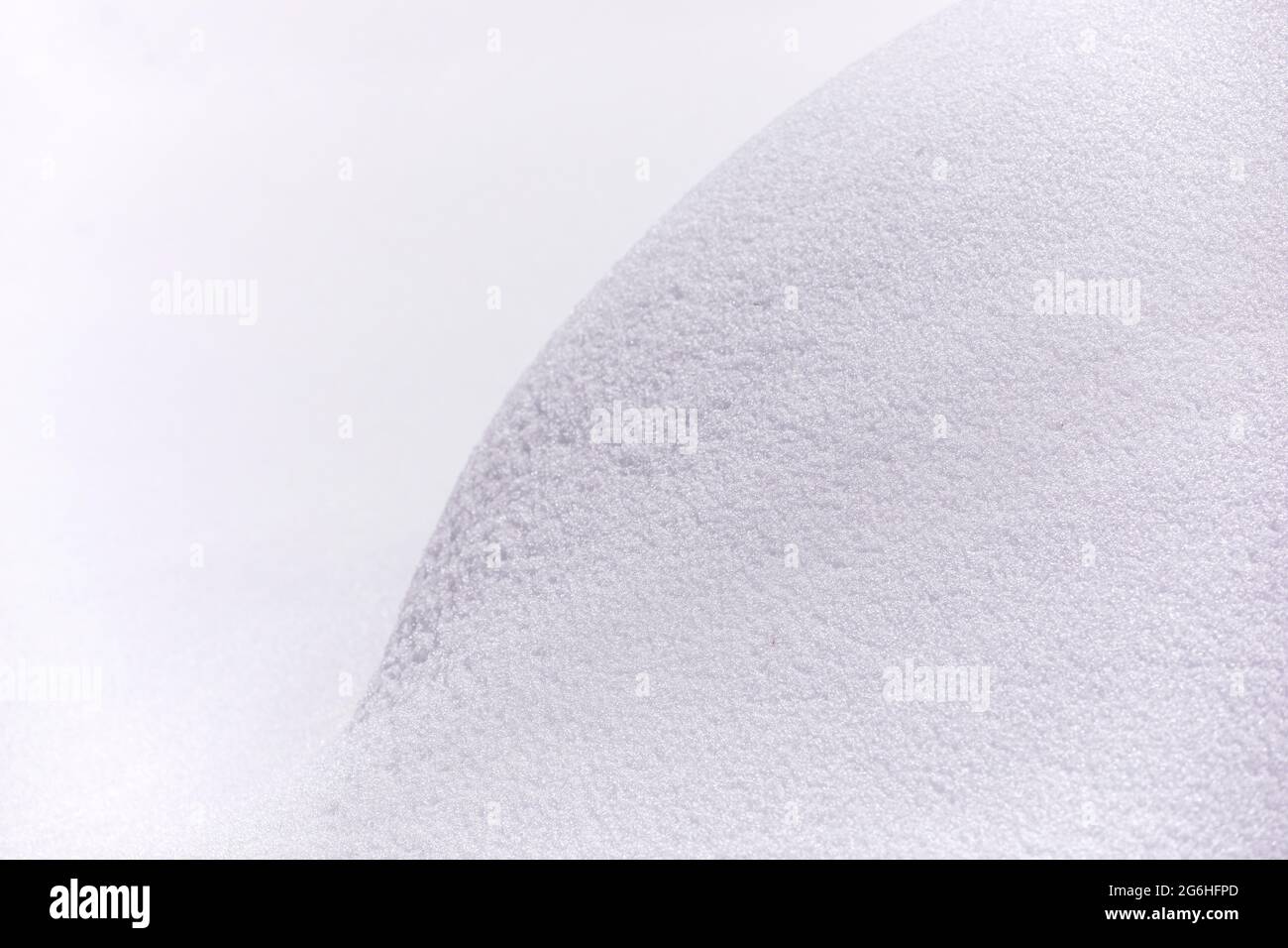 Sfondo della curva della neve. Primo piano di neve deriva con texture visibile, bella forma rotonda linea di neve pura ampie sfumature di pendenza. Foto Stock