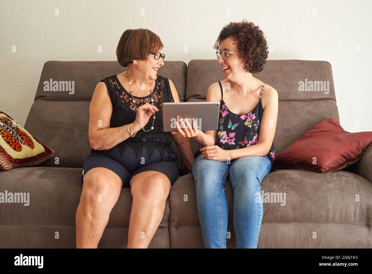 Nonna e nipote ridono mentre guardano i contenuti digitali sul tablet Foto Stock