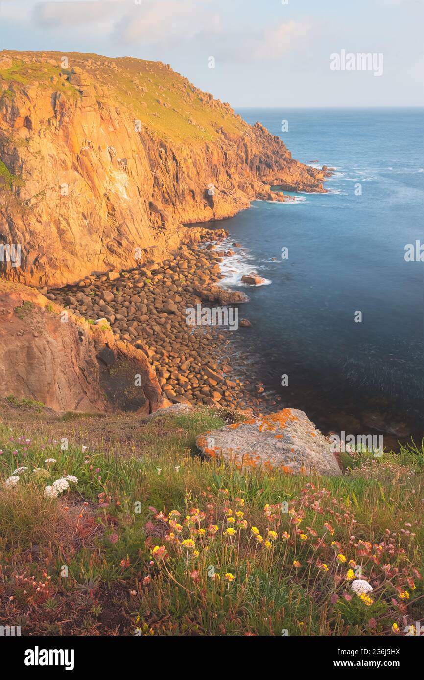 Paesaggio marino di costa rocciosa e punta di Land's End in una serata estiva durante l'ora d'oro in Cornovaglia, Inghilterra, Regno Unito. Foto Stock