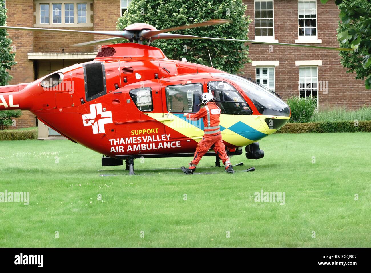 L'equipaggio di Thames Valley Air Ambulance ha chiamato ad uno sviluppo di alloggi per stabilizzare e trasportare un paziente in ospedale. Paramedico si prepara a bordo. Foto Stock