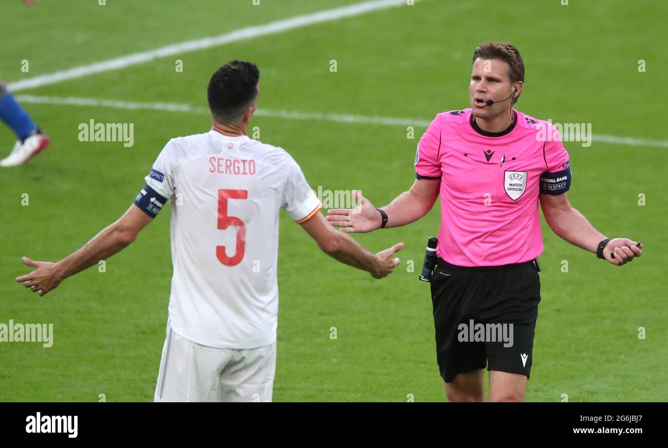 La spagnola Sergio Busquets si rivolge all'arbitro Felix Brych per un tempo extra alla fine del primo tempo durante la partita semifinale UEFA Euro 2020 allo stadio Wembley di Londra. Data immagine: Martedì 6 luglio 2021. Foto Stock