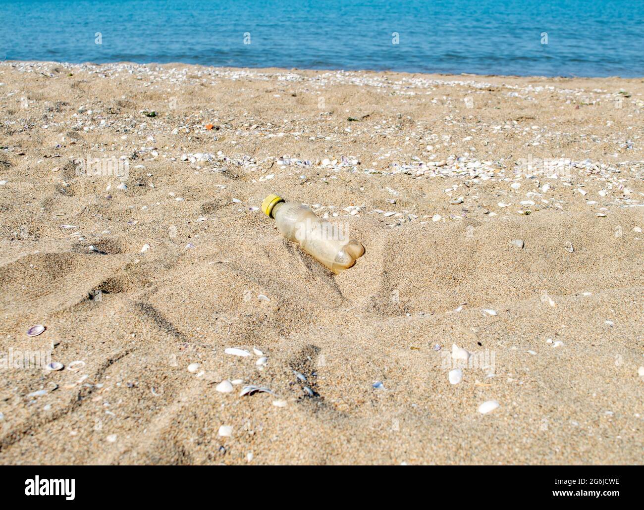 Bottiglia d'acqua di plastica gialla di scarto sulla spiaggia.Beat plastica Pollution.beach pollution.plastic bottiglie sul mare Beach.ecological Concept.Close-up. Foto Stock