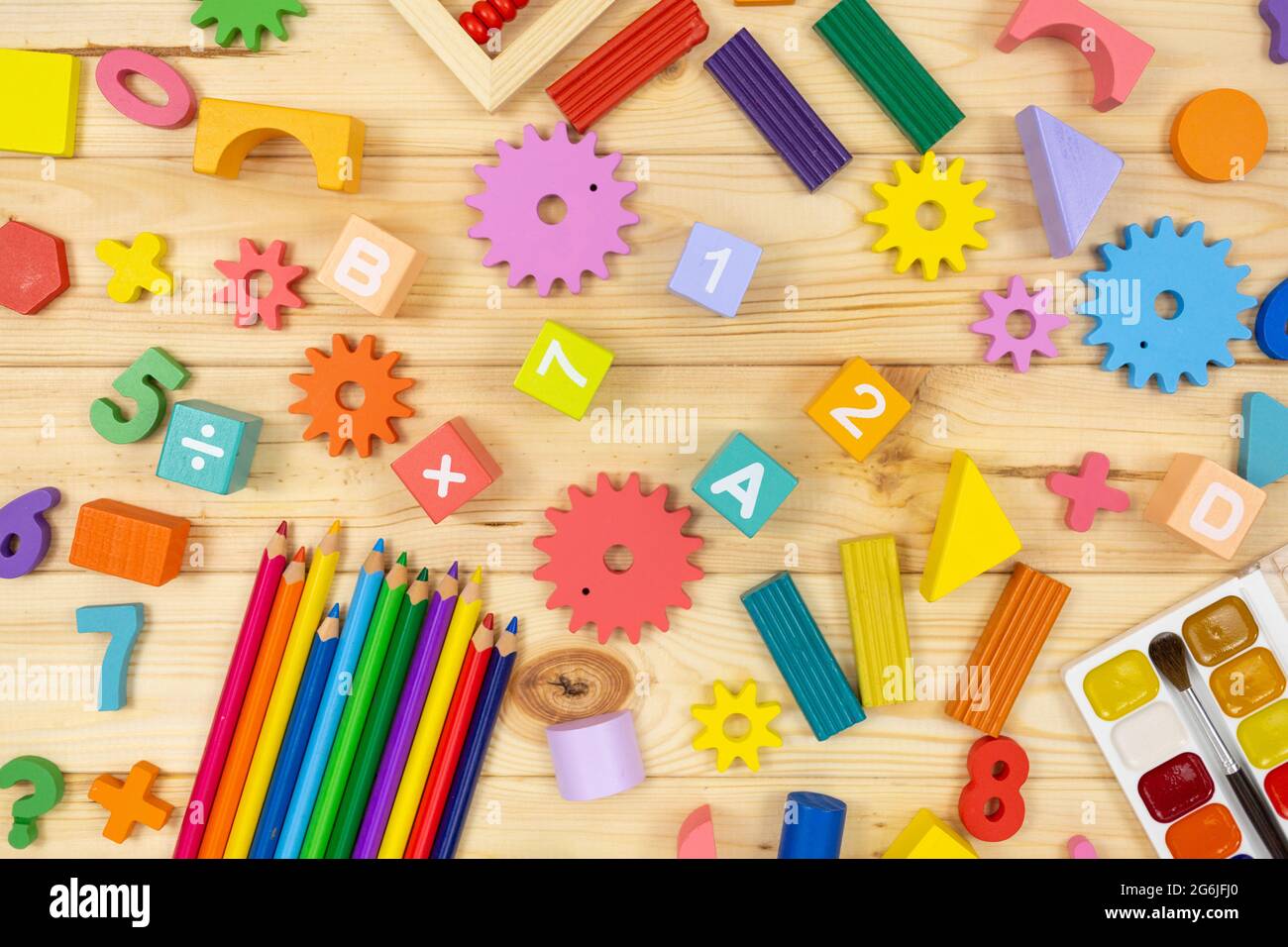 Frazioni matematiche colorate, cubi, matite su tavola di legno. Matematica interessante per i bambini. Educazione, concetto di ritorno alla scuola Foto Stock