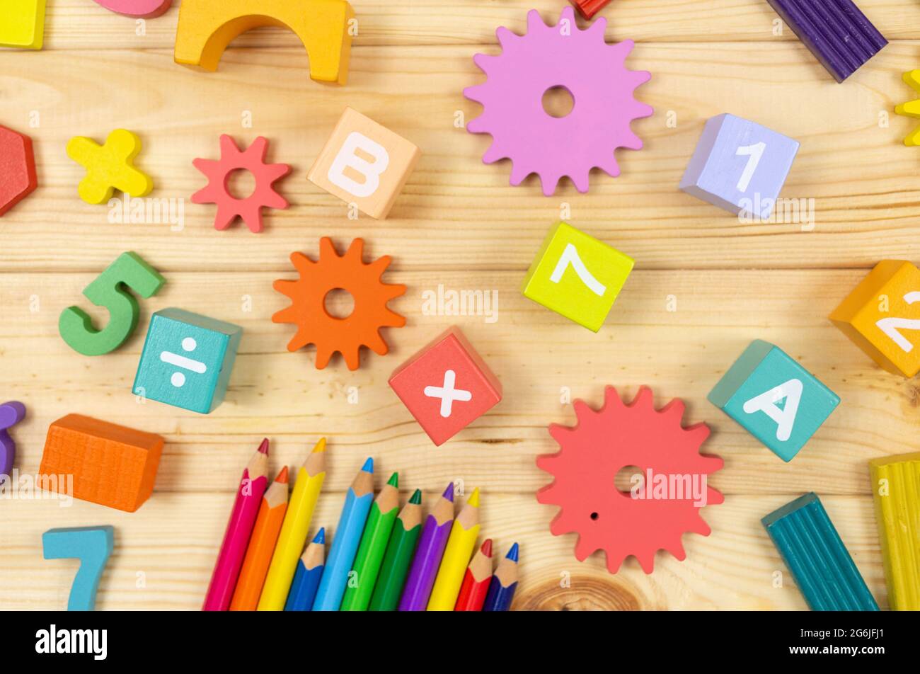 Frazioni matematiche colorate, cubi, matite su tavola di legno. Matematica interessante per i bambini. Educazione, concetto di ritorno alla scuola Foto Stock