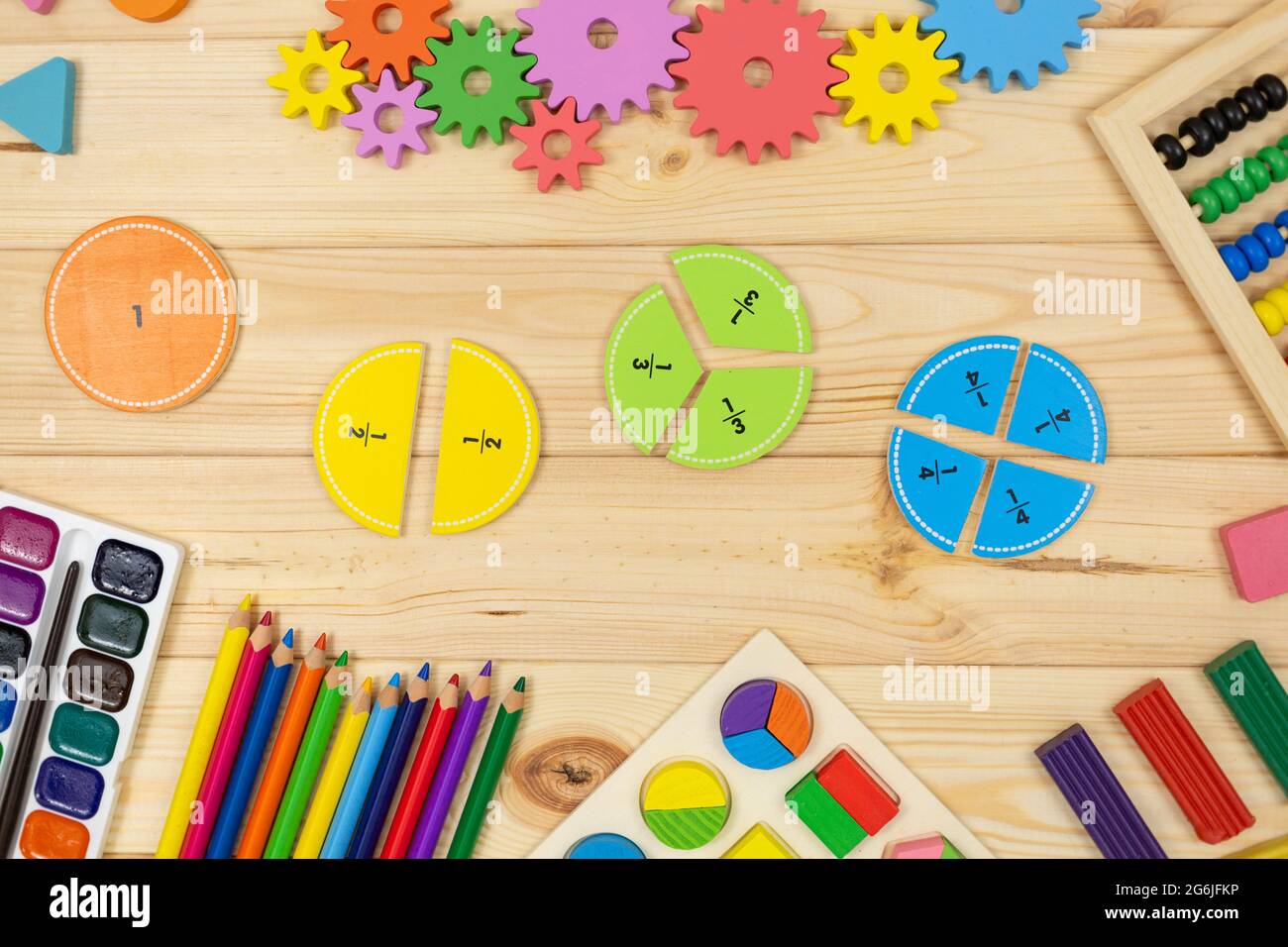 Frazioni matematiche colorate, cubi, matite su tavola di legno. Matematica interessante per i bambini. Educazione, concetto di ritorno alla scuola Foto Stock
