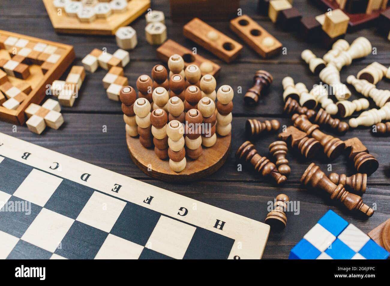 Scacchiera e personaggi scacchi, cubetti di legno, giochi di puzzle su  tavolo di legno scuro. Popolari giochi di logica per il pensiero logico  Foto stock - Alamy