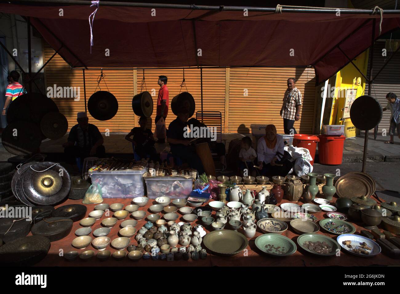 Un fornitore di porcellana, gong e antichità durante il mercato domenicale di Gaya su Gaya Street, Kota Kinabalu, Sabah, Malesia. Foto Stock