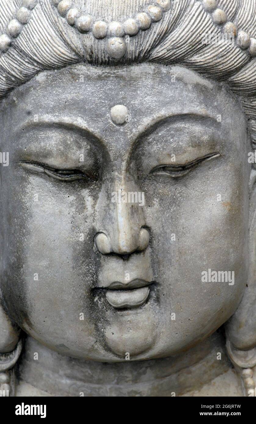 Primo piano di una statua in calcestruzzo di mostra una faccia in pietra e in movimento. Il concetto potrebbe anche essere di mentalità stretta, chiuso occhio, o pensare duro. Foto Stock