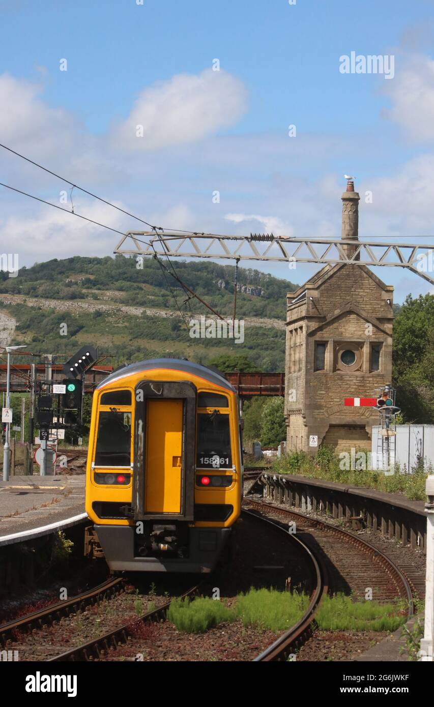 Northern express sprinter dmu passando segnale piuma lasciando Carnforth stazione il 5 luglio 2021. Erbacce in pista e su parte disutilizzata della piattaforma 1. Foto Stock