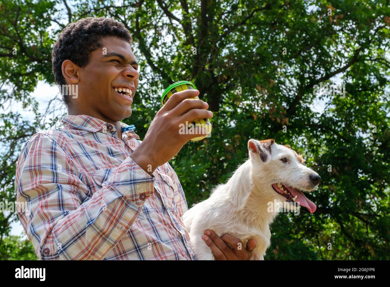 Uomo sorridente che tiene Jack Russell terrier cane e caffè per andare Foto Stock