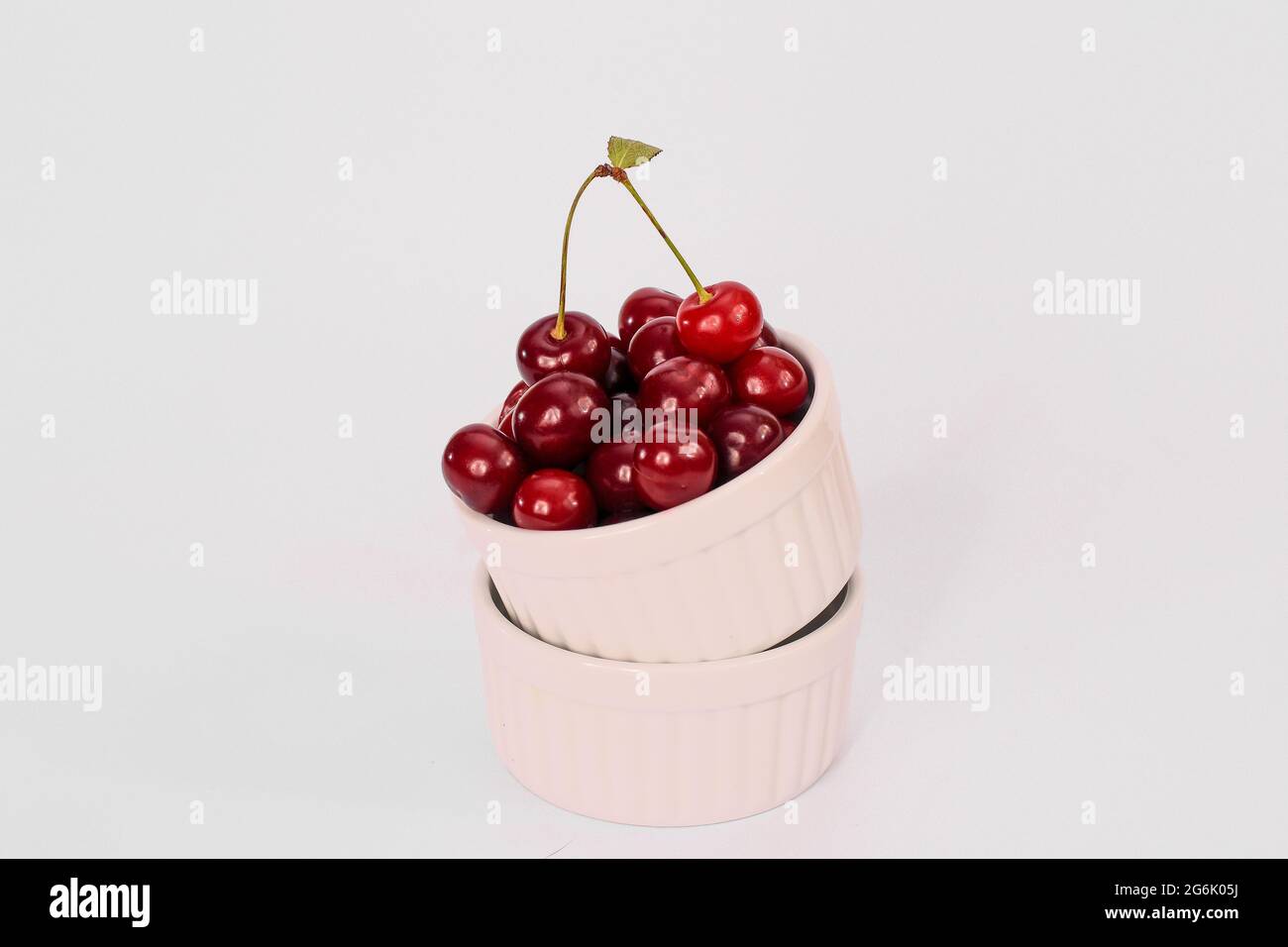 frutta fresca di ciliegia rossa in un piatto su fondo bianco. mock up Foto Stock