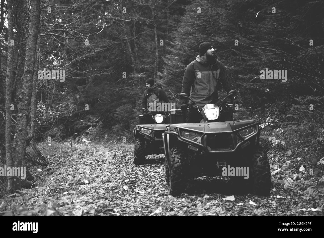 I soccorritori in uniforme protettiva su una Quad Bike osservano i boschi per cercare e salvare la persona mancante Foto Stock