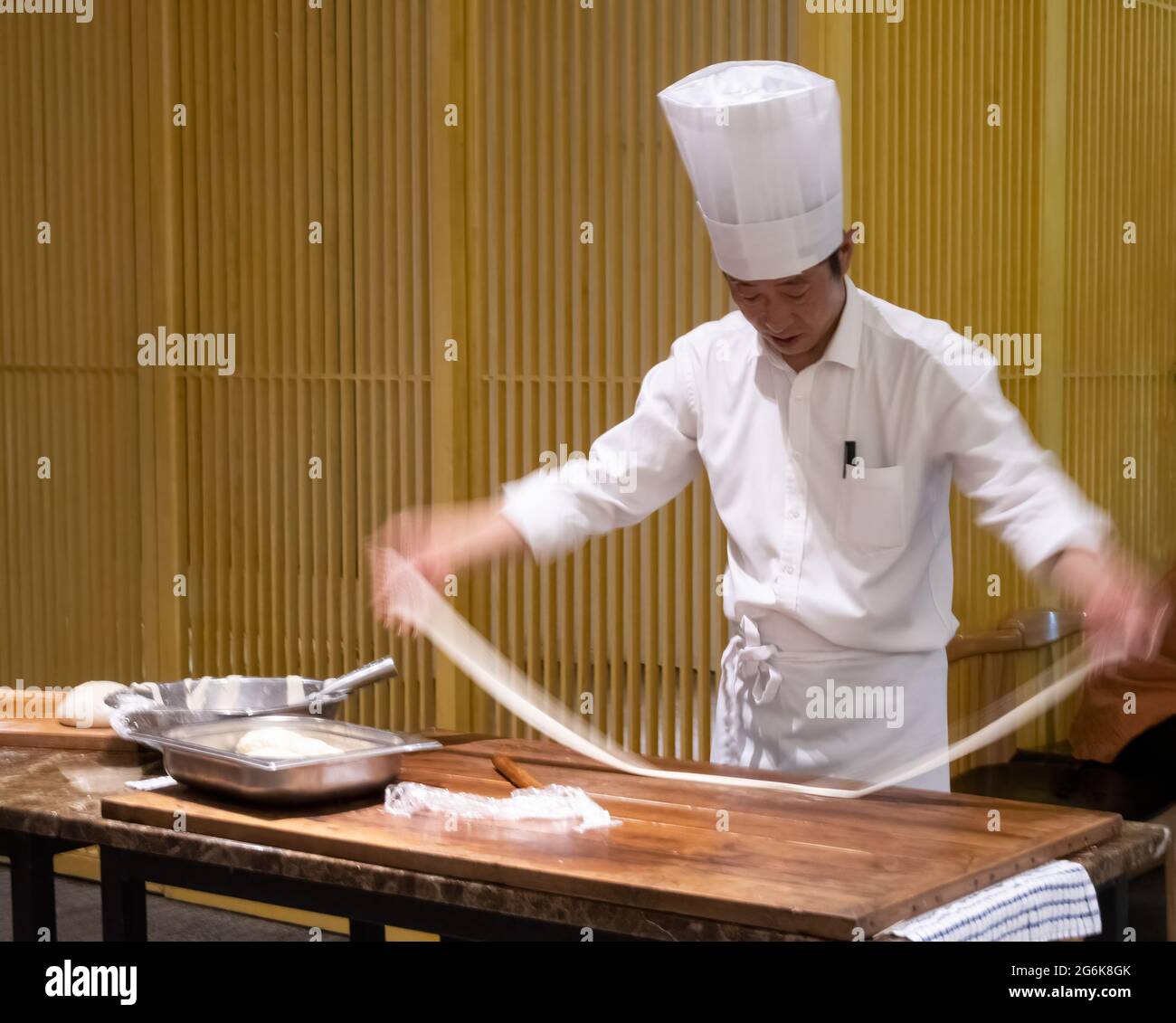 Uno chef produce spaghetti biang, conosciuti anche come spaghetti 'cintura' per il loro spessore e lunghezza, a Xi'an, nella provincia di Shaanxi, in Cina. Foto Stock