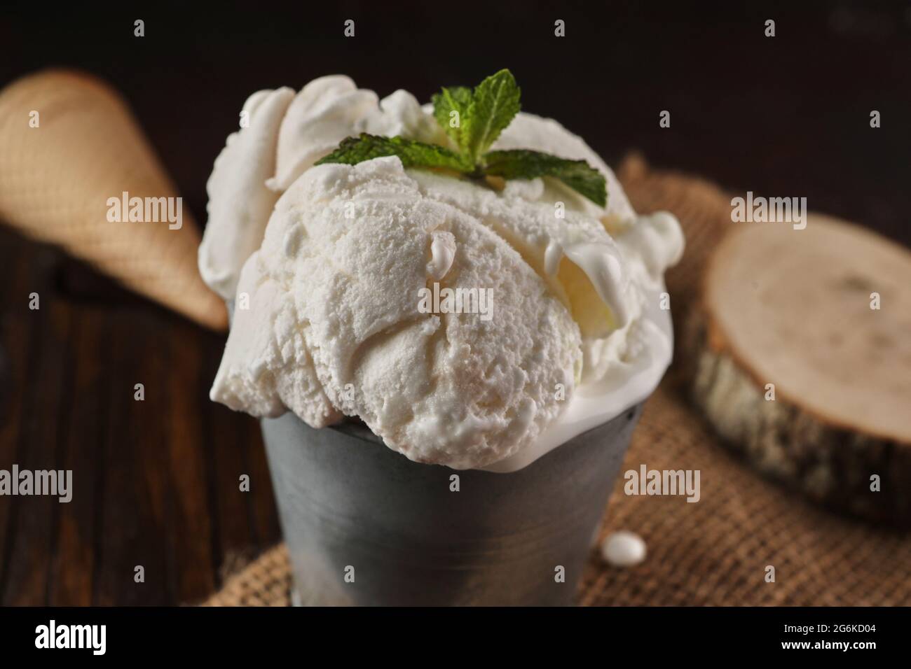 Gelato cremoso in secchio su sfondo di legno e burlap in stile rustico Foto Stock