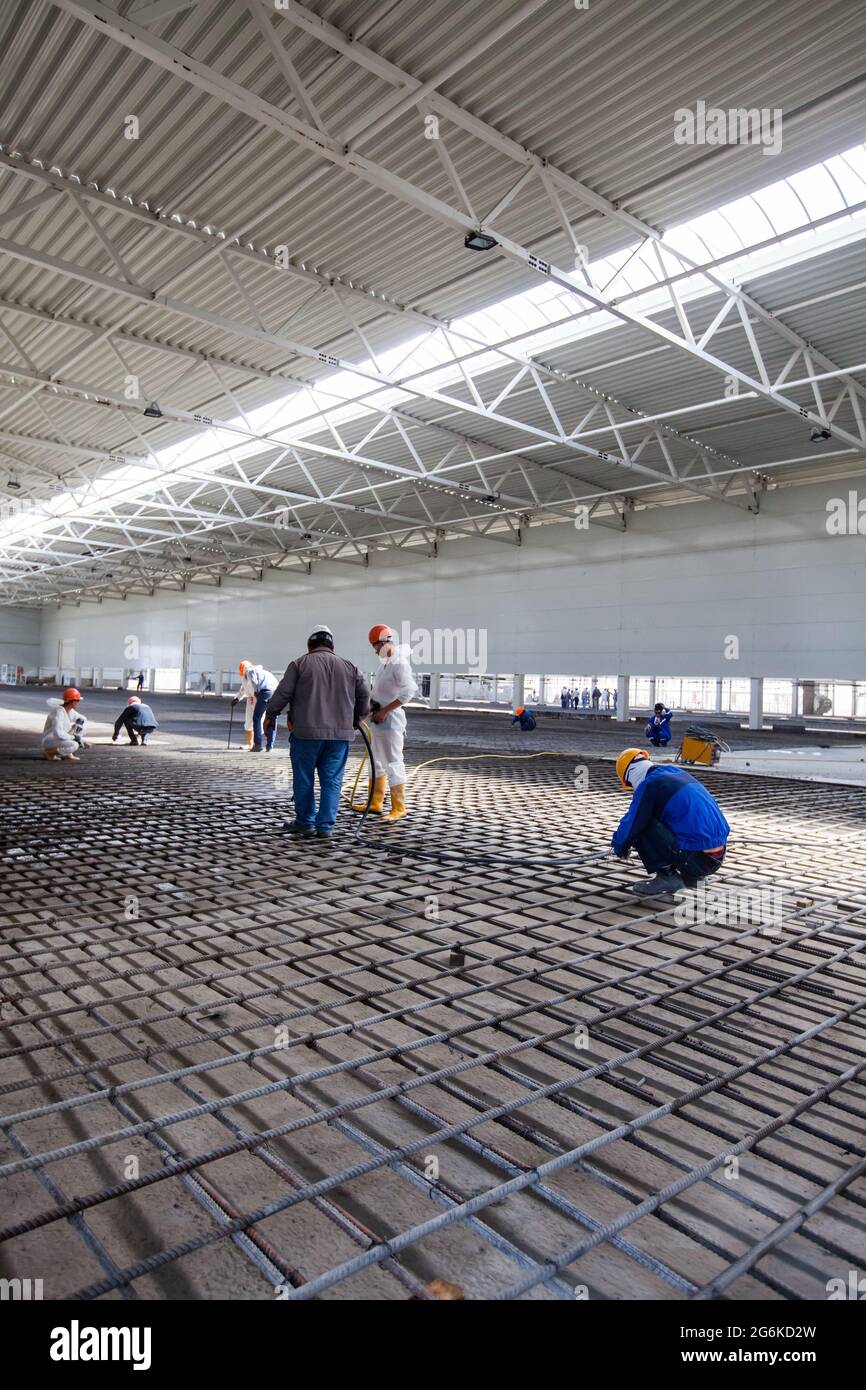 Atyrau, Kazakhstan - Maggio 21,2012: Interno della fabbrica di Chevron. Costruzione di edifici industriali. Costruttori che fanno pavimento di cemento di rinforzo. Openwor Foto Stock