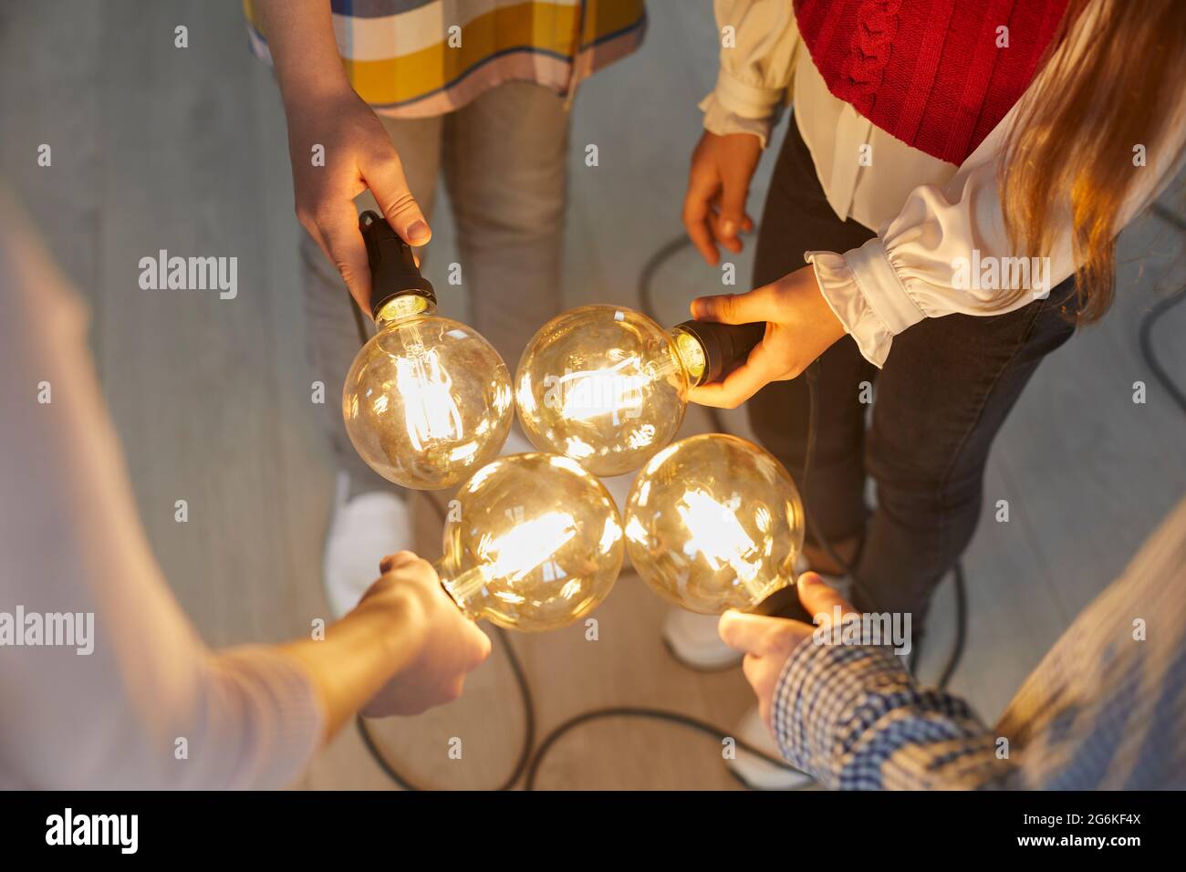 Un gruppo di uomini d'affari che tengono lampadine. Foto Stock