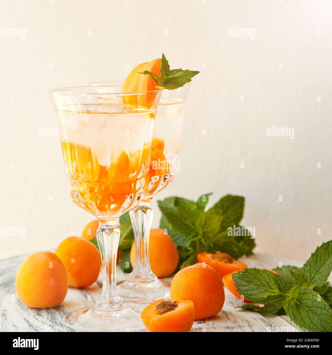 Bevande estive, cocktail di albicocche alla menta con ghiaccio in bicchieri. Rinfrescanti cocktail estivi alcolici o non alcolici fatti in casa o infusi Detox aromatizzati Foto Stock