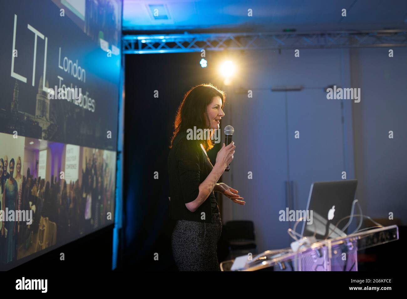 Una donna d'affari che dà una presentazione sul palco a Londra Foto Stock