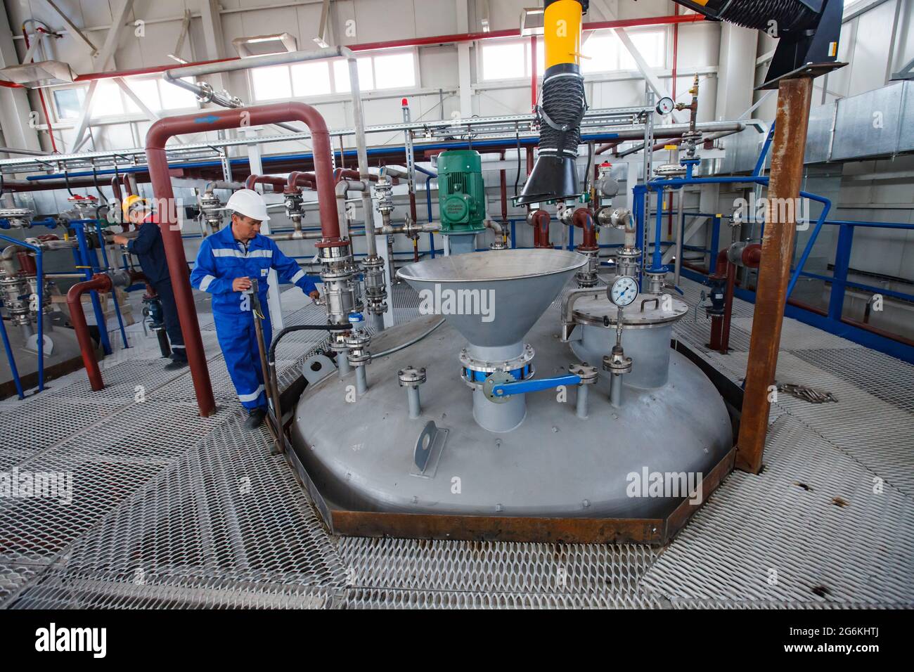 Atyrau, Kazakistan-Maggio 21,2012: Impianto chimico Rauan Nalco. Tecnici che regolano l'attrezzatura. Braccio estrattore fumi (collettore polveri) con cappa. Metallo grigio f Foto Stock