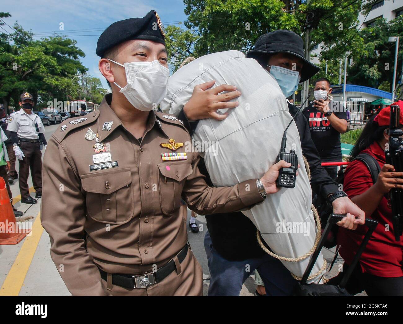 Nonthaburi, Tailandia. 07 luglio 2021. Un attivista del gruppo civile thailandese porta una simulazione di un corpo COVID-19 mentre un poliziotto cerca di bloccarlo durante una protesta al di fuori del Ministero della Sanità pubblica. Per chiedere al governo di procurarsi vaccini alternativi Covid-19 per il pubblico, compresi bambini e medici professionisti, i manifestanti hanno portato al Ministero della Sanità pubblica con corpi morti fittizio per simboleggiare le vittime Covid-19 che sono morte a causa della mancanza di vaccini. (Foto di Chaiwat Subprasom/SOPA Images/Sipa USA) Credit: Sipa USA/Alamy Live News Foto Stock