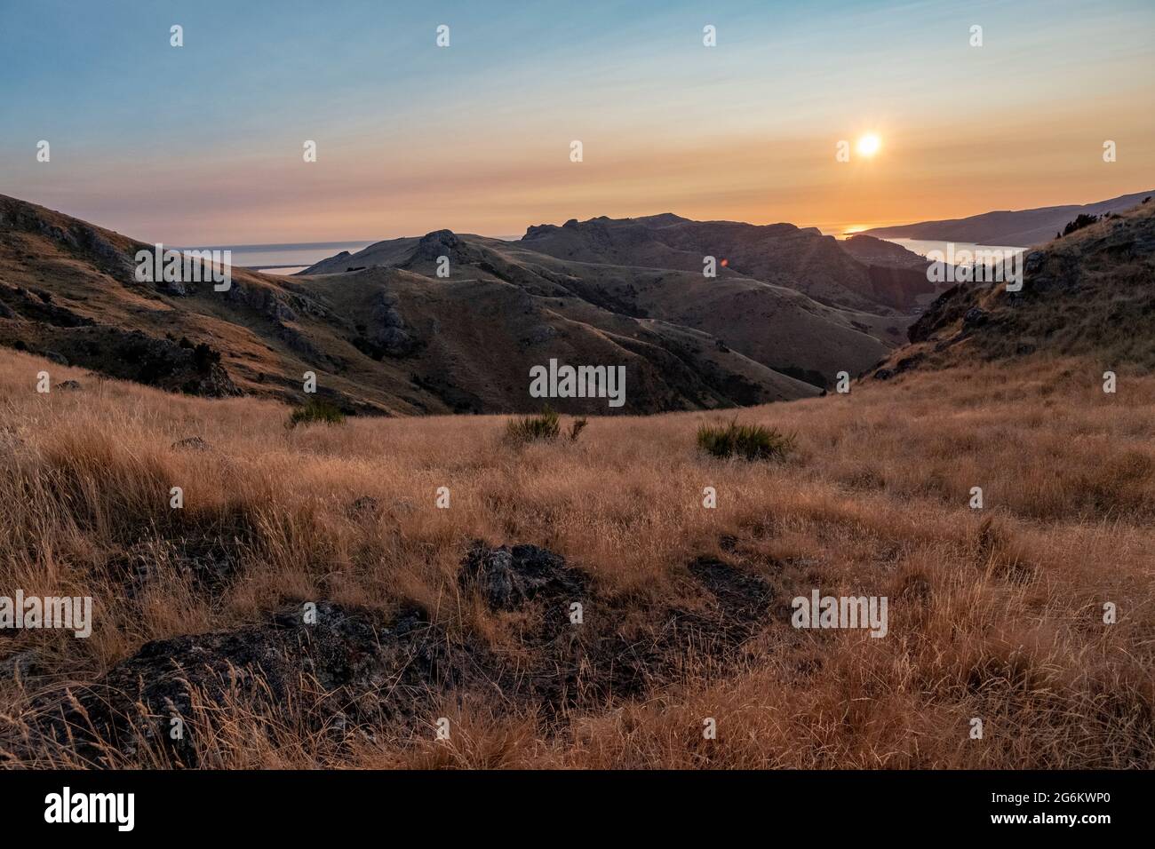 Alba su Porthills, Christchurch, Aotearoa Nuova Zelanda. Le Port Hills sono un residuo di 12 milioni di anni del cratere del vulcano Lyttelton. Vento, ra Foto Stock
