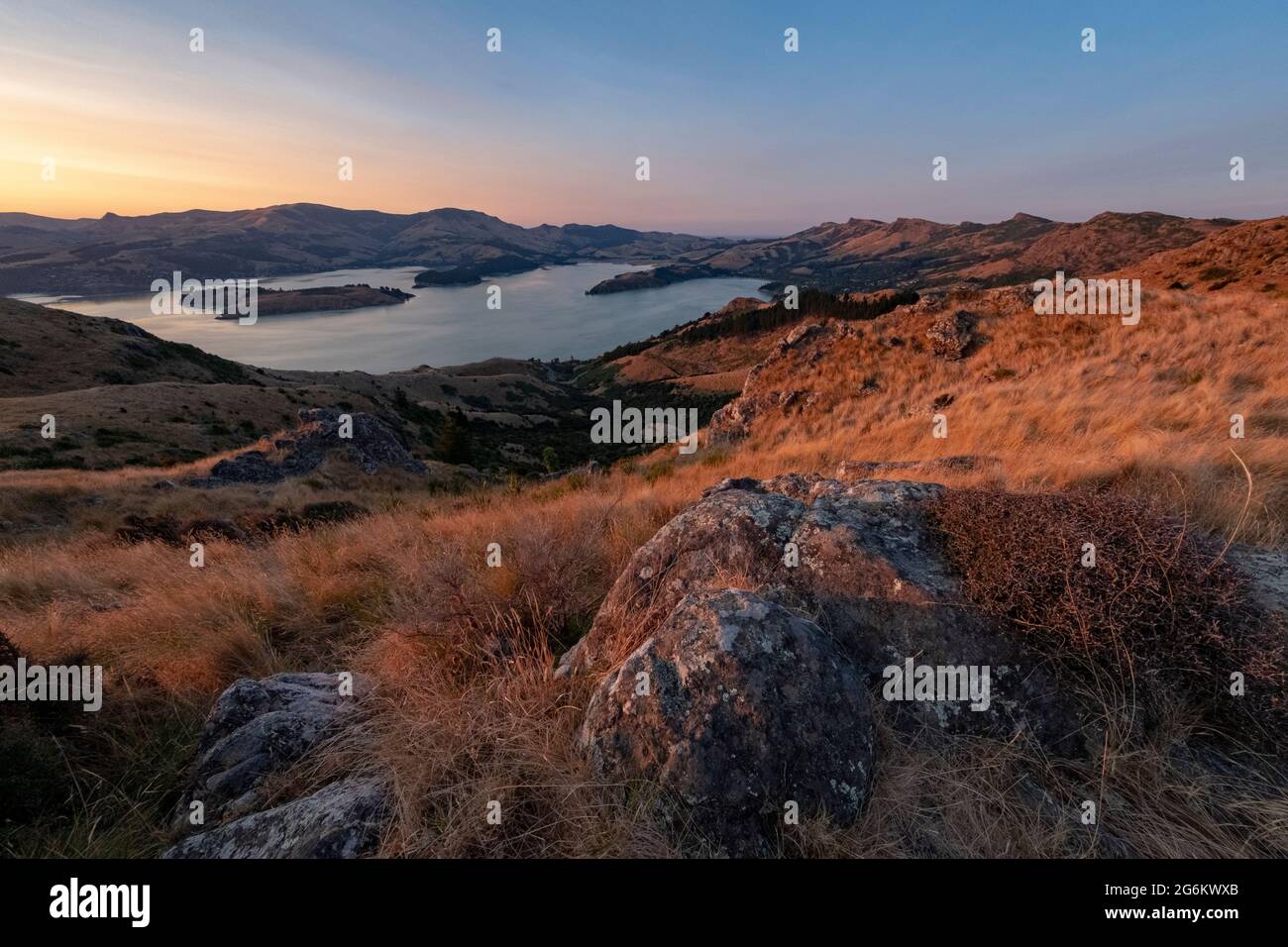 Alba su Porthills, Christchurch, Aotearoa Nuova Zelanda. Le Port Hills sono un residuo di 12 milioni di anni del cratere del vulcano Lyttelton. Vento, ra Foto Stock