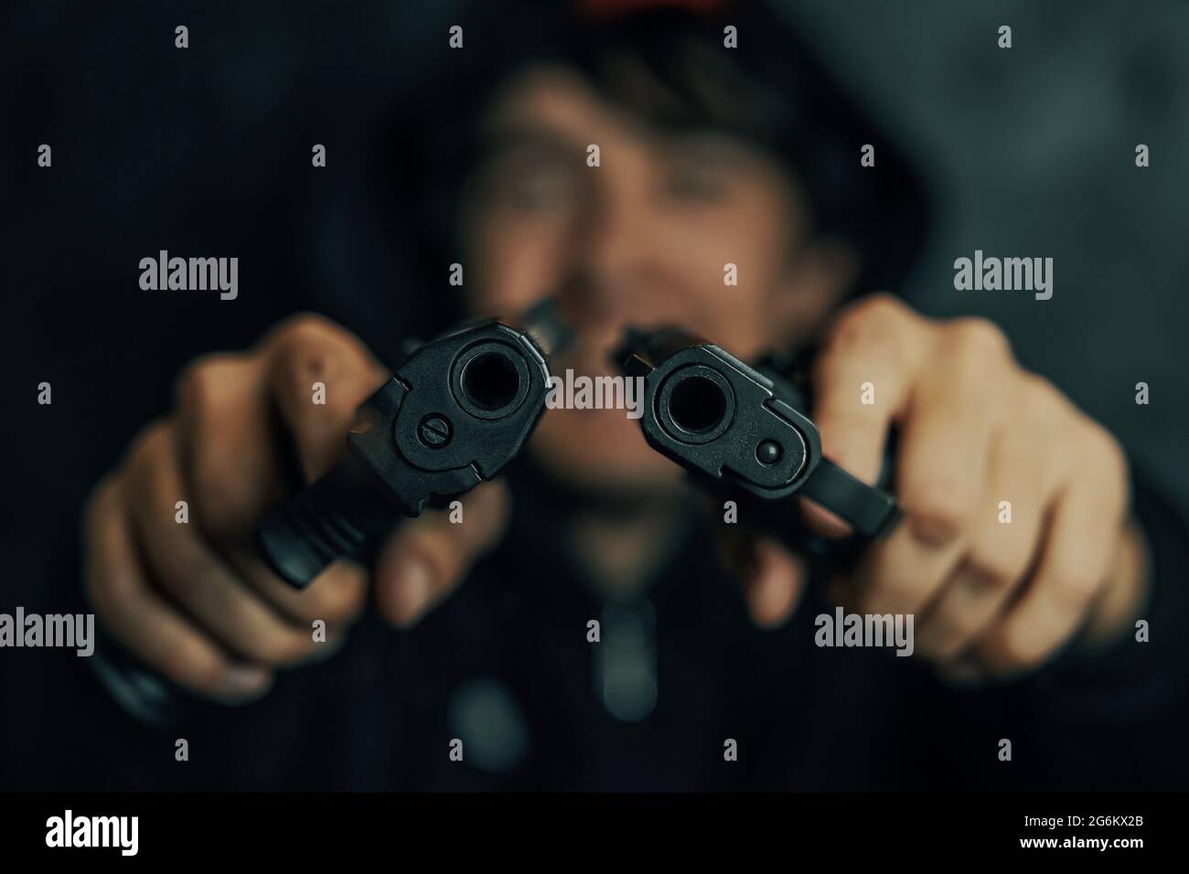 Primo piano di due mazzelle da pistola. Due pistole nelle mani dell'uomo sono puntate alla macchina fotografica. Guy minaccia con l'arma da fuoco. Criminale con arma. Foto Stock