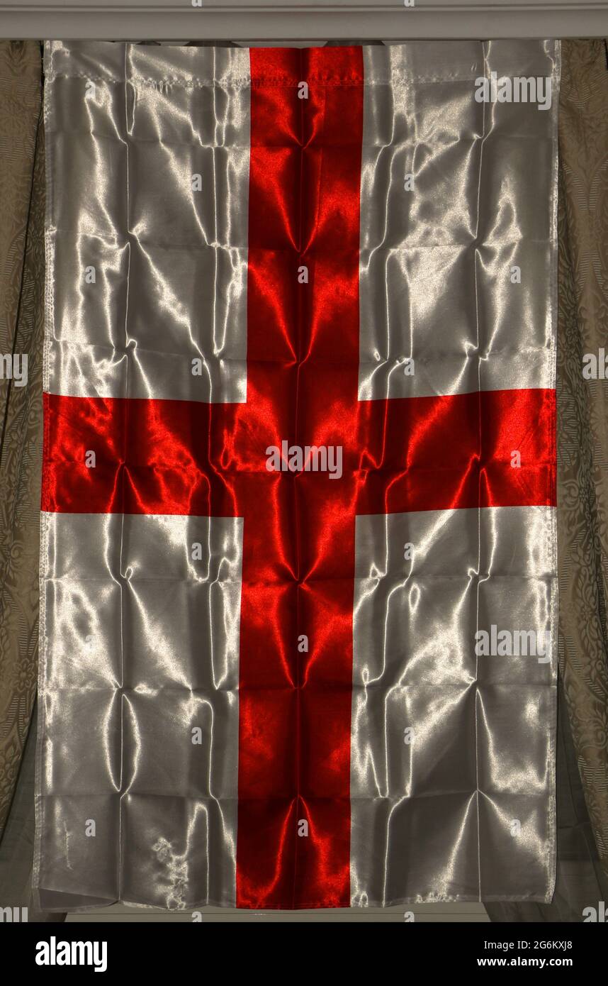 Foto di una bandiera nazionale inglese rossa e bianca appesa tra le tende  come decorazione di finestre interne per i ritardati 2020 euro che si  tengono nel 2021 Foto stock - Alamy