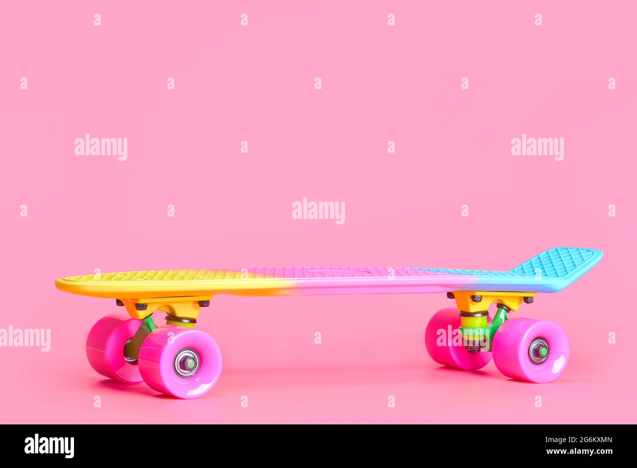 rainbow Plastic Penny skateboard isolato su sfondo rosa Foto Stock