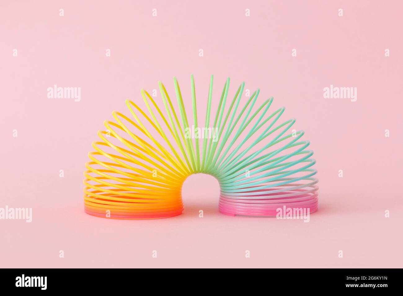 Rainbow plastica primavera giocattolo su sfondo rosa Foto Stock