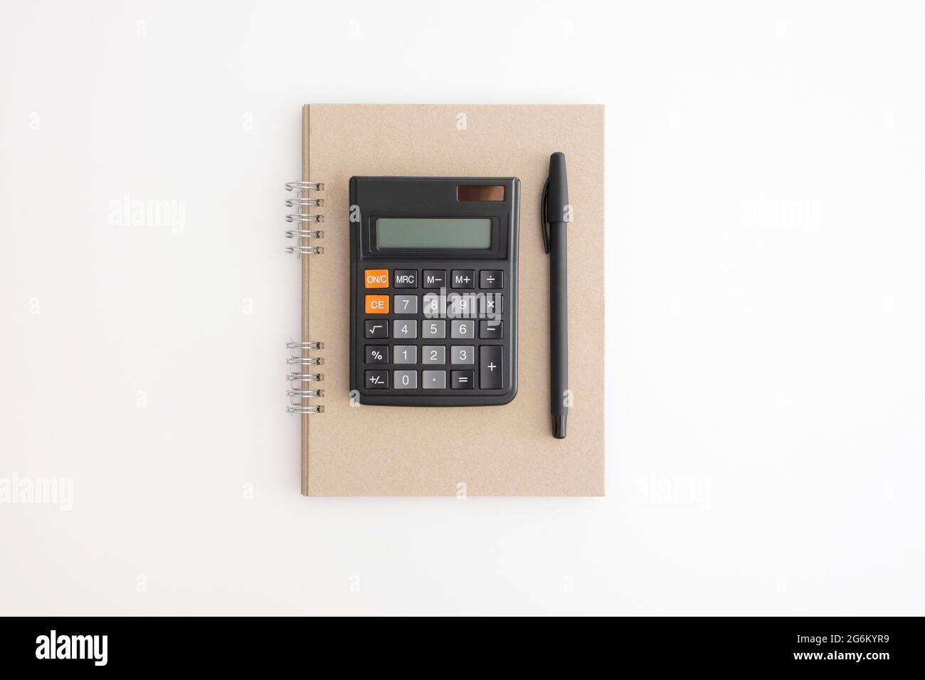 Calcolatrice, notebook e penna su sfondo bianco Foto Stock