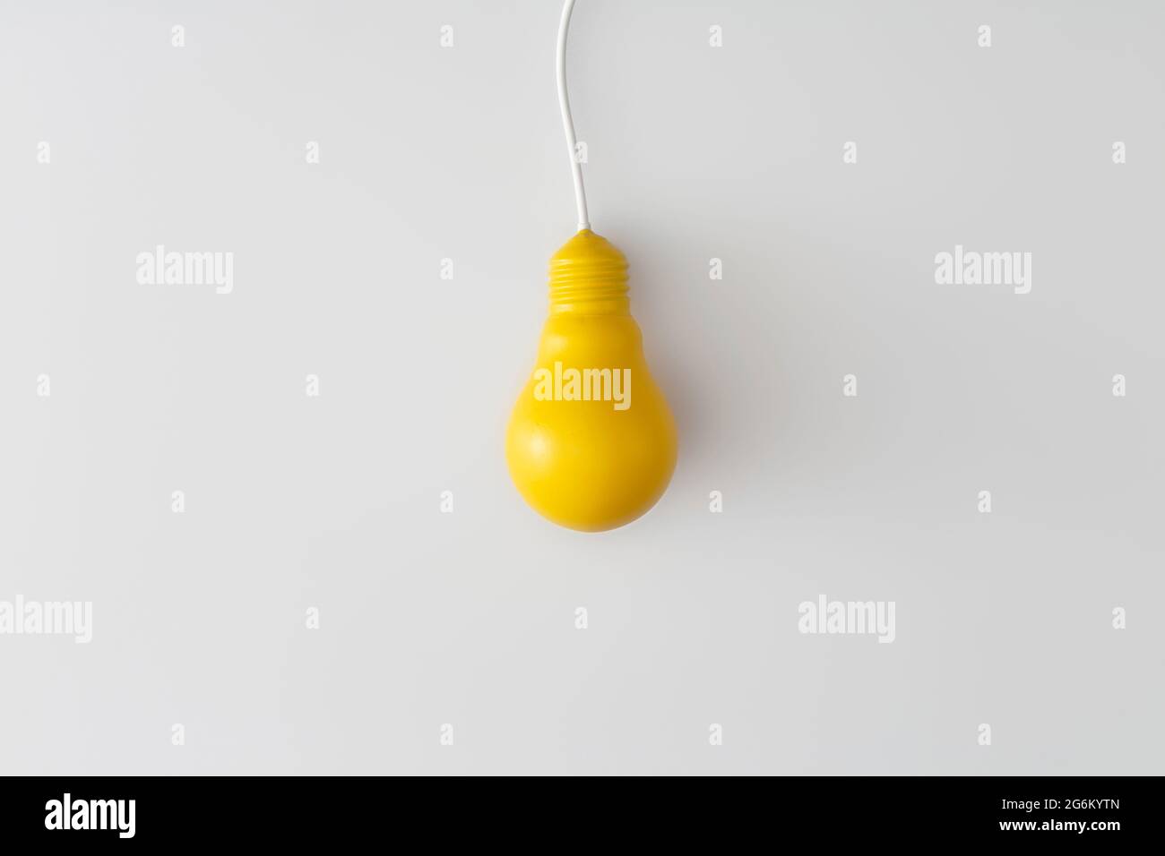 Lampadina gialla su sfondo bianco. Concetto di ispirazione e idea creativa. Vista dall'alto con spazio per la copia. Composizione di posa piatta. Foto Stock