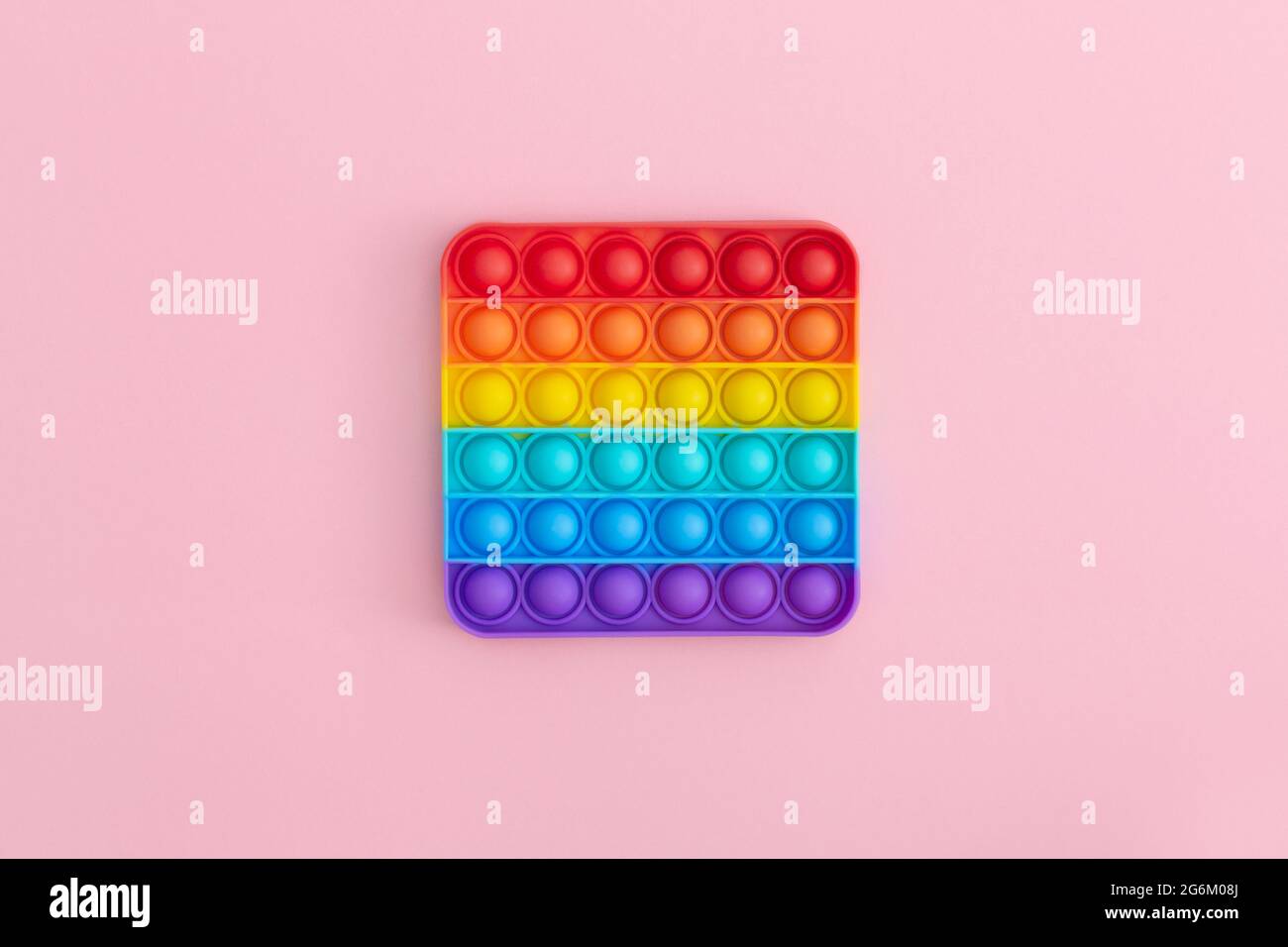 Giocattoli sensoriali colorati anti-stress pop IT per bambini su sfondo rosa. Foto Stock