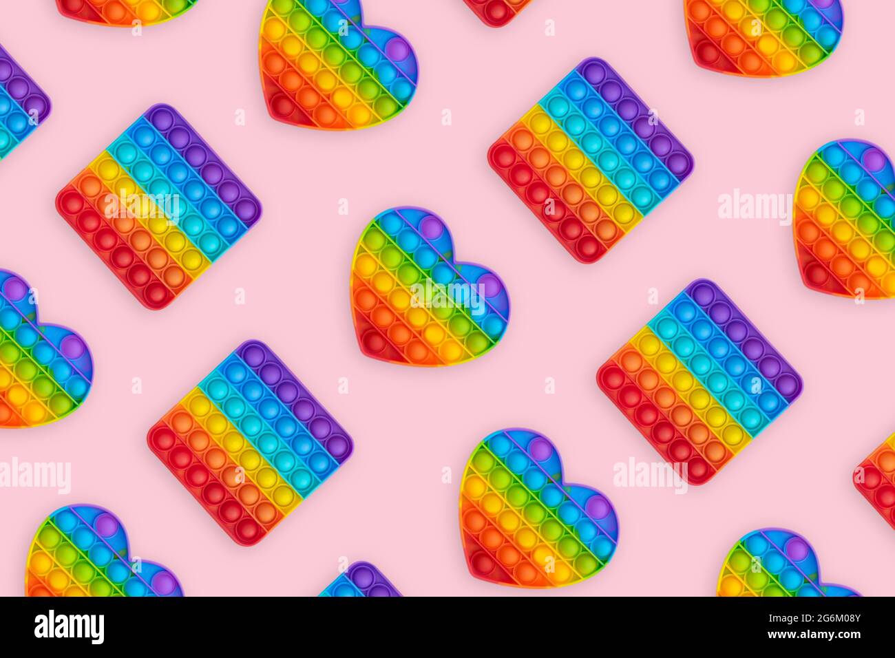 Giocattoli sensoriali colorati anti-stress pop IT per bambini su sfondo rosa. Foto Stock