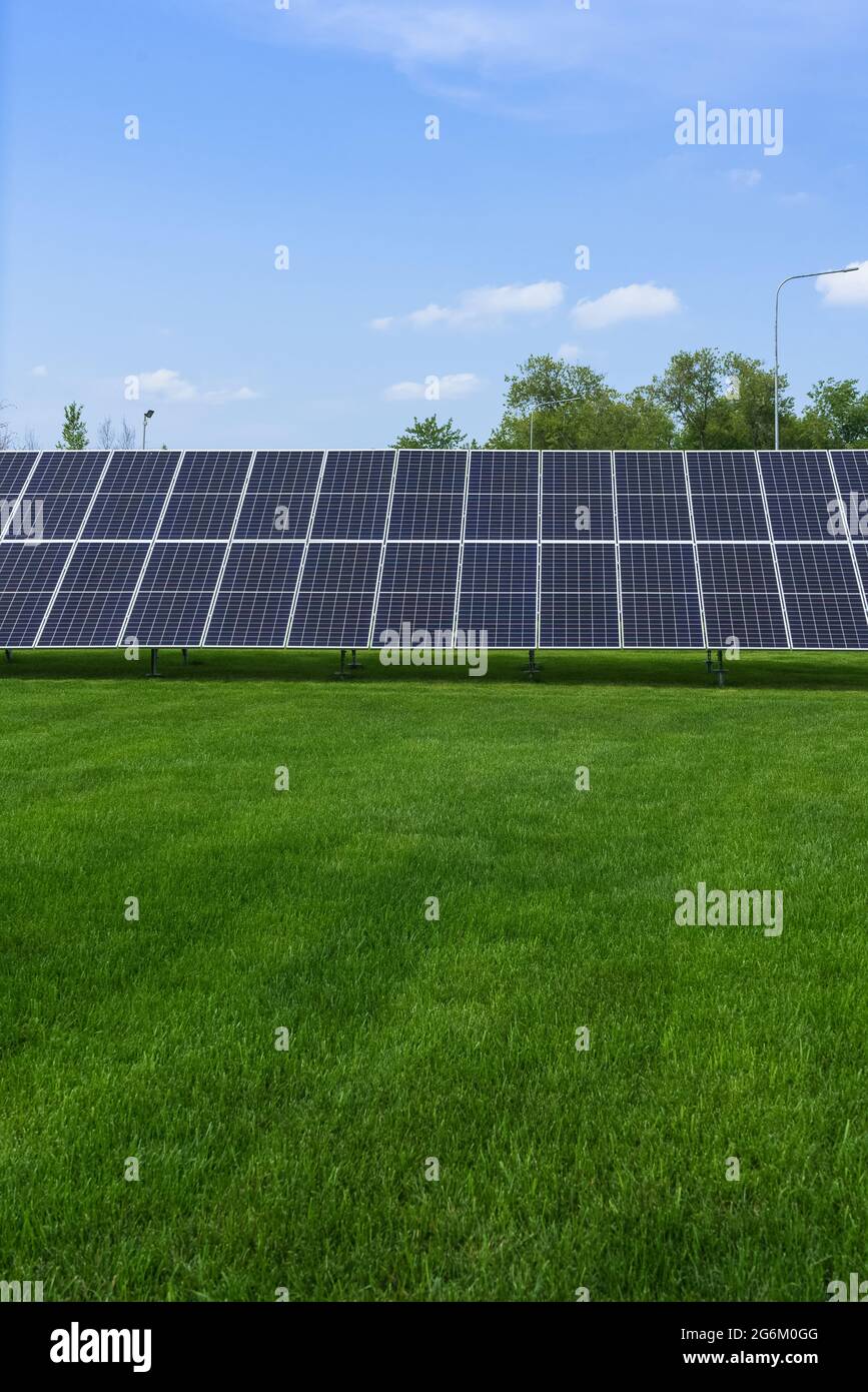 vista ravvicinata del pannello solare con prato verde e cielo blu Foto Stock